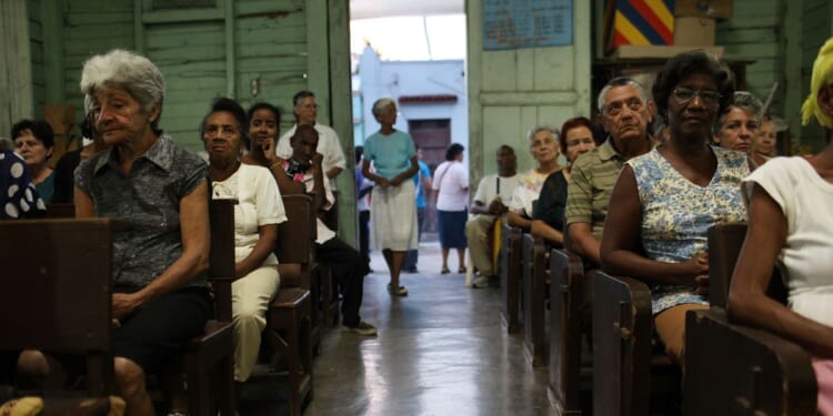 Parishioners sit and listen during a Catholic Church service in a poor suburb in Santiago de Cuba, Cuba on March 24, 2012.