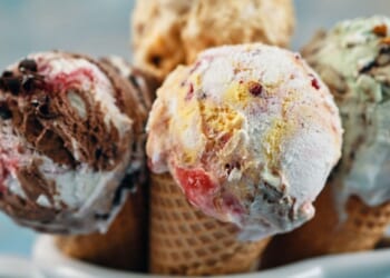 A variety of ice cream flavors in cones.