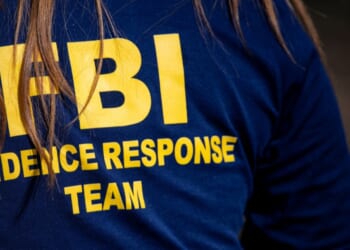 A member of the FBI surveils a crime scene in Tucson, Arizona, on Feb. 11, 2026.