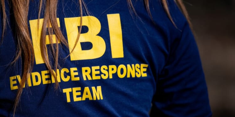 A member of the FBI surveils a crime scene in Tucson, Arizona, on Feb. 11, 2026.