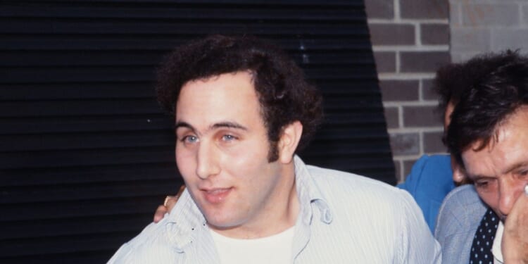 Police officers escort accused and ultimately convicted serial killer David Berkowitz, known as the Son of Sam, into the 84th precinct station in New York on Aug. 10, 1977.