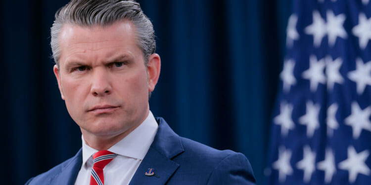 Close-up of Secretary of War Pete Hegseth as he speaks to reporters.