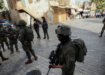 Israeli soldiers stand in the way of reporters recording with their cameras in the Old City of Hebron, in the West Bank, on May 9, 2026.