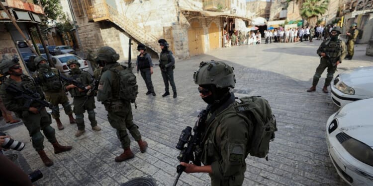 Israeli soldiers stand in the way of reporters recording with their cameras in the Old City of Hebron, in the West Bank, on May 9, 2026.