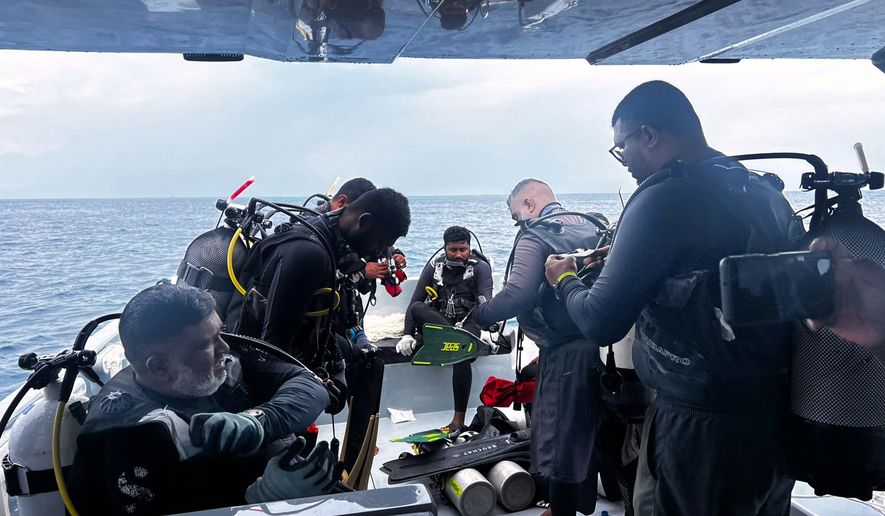 This image released by the Maldives President's Media Division, shows divers preparing to search for the four missing Italian divers near Alimathaa Island, Vaavu Atoll, Maldives, Saturday, May 15, 2026. (Maldives President's Media Division via AP)