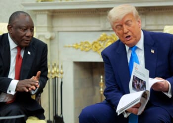 President of South Africa Cyril Ramaphosa looks on as President Donald Trump displays articles he says report violence against white South Africans in the Oval Office of the White House on May 21, 2025, in Washington, D.C.