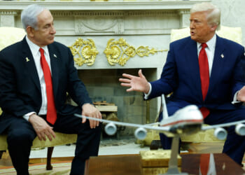 Donald Trump gestures to Benjamin Netanyahu as they sit in the Oval Office.