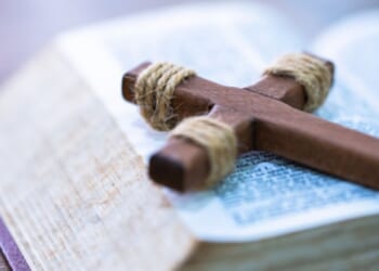 A crucifix lays on a Bible.
