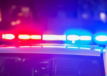 The roof of a police patrol car at night, with the blue and red lights flashing.
