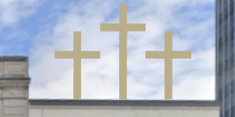 Three golden crosses stand on top of a building.
