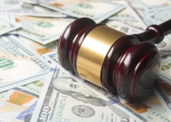 A gavel sits on a pile of cash.