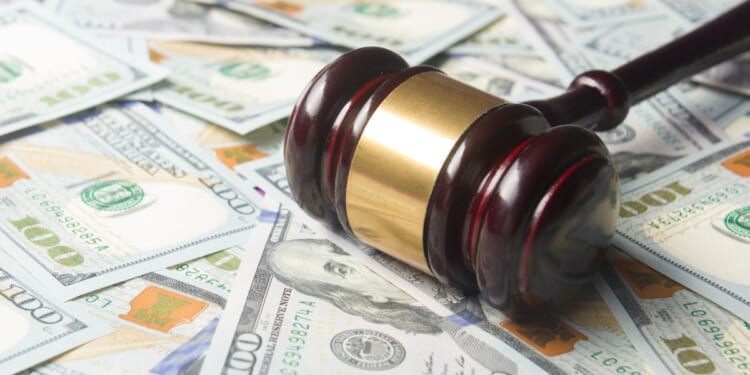 A gavel sits on a pile of cash.