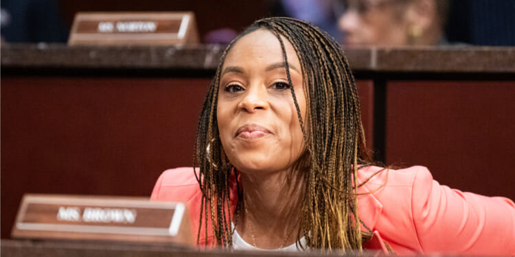 Shontel Brown smiles as she looks ahead while sitting for a committee hearing.