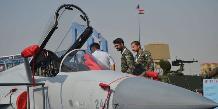 Military officials look at an Pakistan's JF-17 Thunder aircraft during International Defence Exhibition and Seminar 2022 at the Expo Centre in Karachi on Nov. 16, 2022.