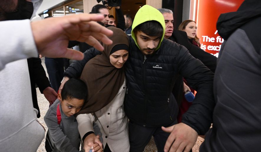 A group of supporters surrounds a woman and child with alleged ties to the Islamic State as they arrive at Melbourne International Airport, in Melbourne, Australia, Thursday, May 7, 2026. (Joel Carrett/AAP Image via AP, File)