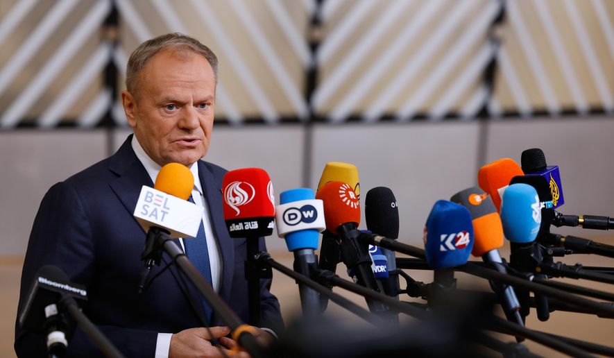Poland's Prime Minister Donald Tusk speaks with the media as he arrives for the EU Summit in Brussels, Thursday, Dec. 18, 2025. (AP Photo/Geert Vanden Wijngaert, File)