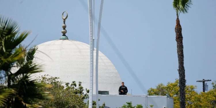 A police officer stands guard as emergency workers respond at the scene of a reported active shooter situation at the Islamic Center in San Diego, California, U.S., May 18, 2026. REUTERS/Mike Blake