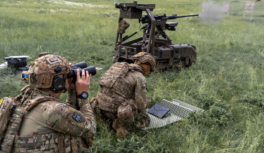 Ukrainian servicemen of the Cerberus Ground Unmanned Systems Company of the 60th Separate Mechanized Brigade, Third Army Corps, conduct a drill with a combat ground drone during a training at the polygon in Kharkiv region, Ukraine, Sunday, May 24, 2026. (AP Photo/Andrii Marienko)