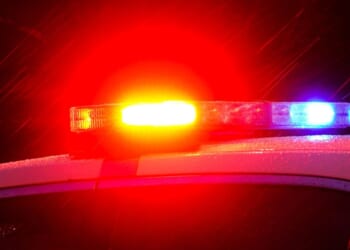 The lights on top of a police car flash at night.