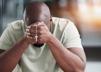 Man praying the rosary.