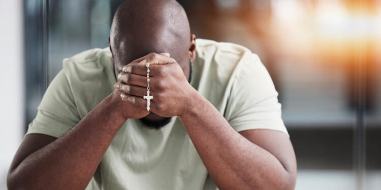 Man praying the rosary.