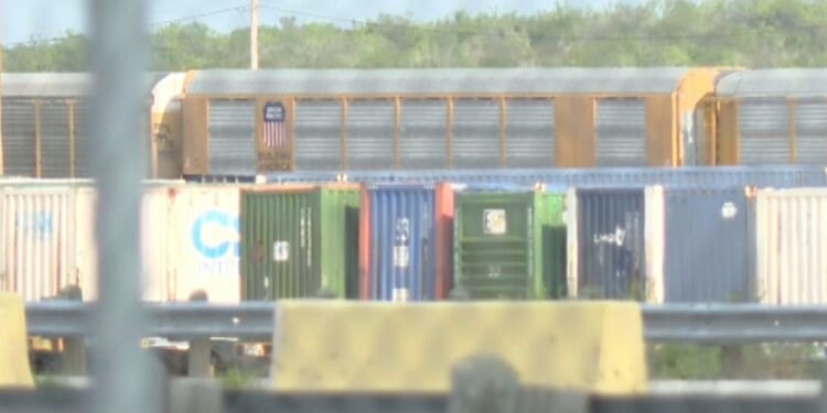 Union Pacific train cars can be spotted through a gate stationed at the rail yard in Laredo, Texas.