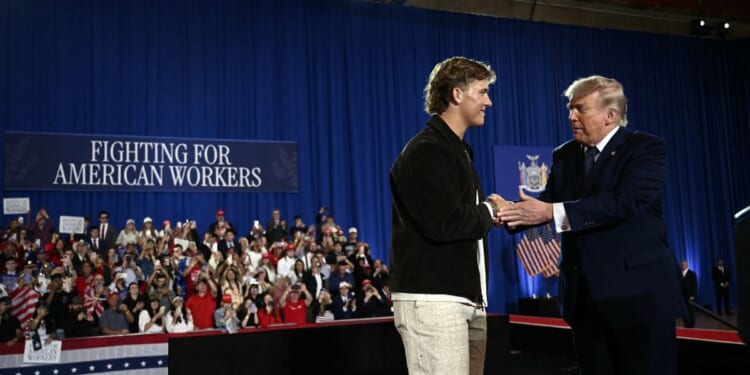 President Donald Trump is welcomed by New York Giants quarterback Jaxson Dart before delivering a speech about the economy at Rockland Community College Fieldhouse in Suffern, New York, on May 22, 2026.