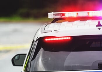 A stock image of a police car with flashing lights.