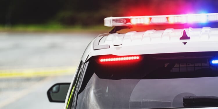 A stock image of a police car with flashing lights.