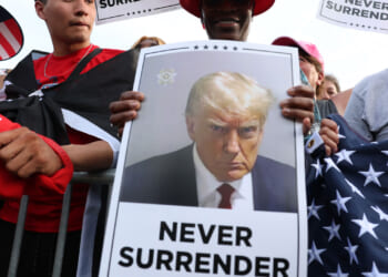 A Trump supporter holds a photo of Donald Trump never surrender. (Spencer Platt/Getty Images)