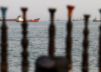 Tankers on the Strait of Hormuz as seen through posts on an Iranian beach.
