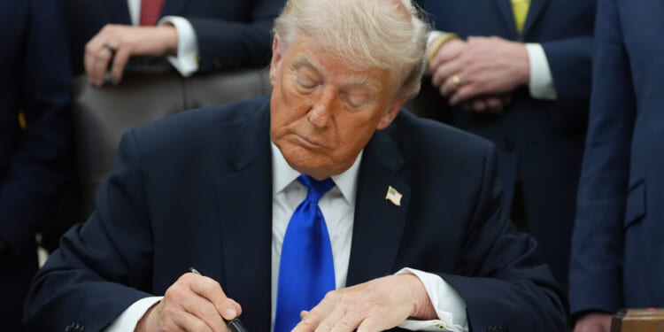 President Donald Trump signs a presidential permit regarding pipeline construction in the Oval Office of the White House Thursday.