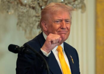 President Donald Trump grins and pumps his fist in a February file photo at a White House event for Black History Month.
