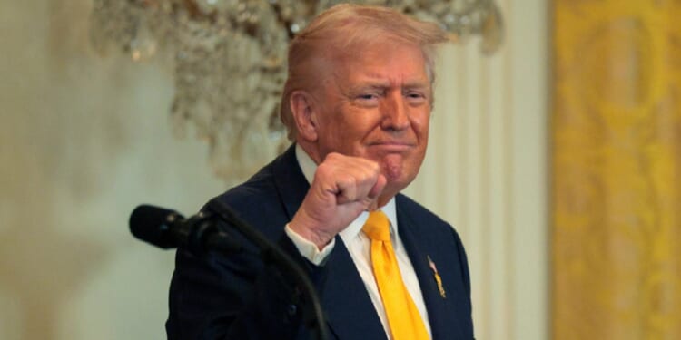 President Donald Trump grins and pumps his fist in a February file photo at a White House event for Black History Month.