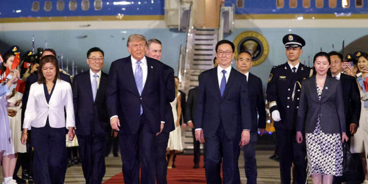 U.S. President Donald Trump walks to his motorcade as he is greeted by Chinese officials at Beijing Capital International Airport.