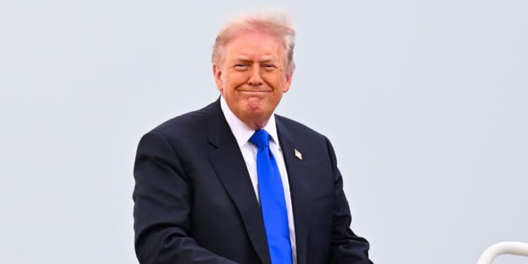 President Donald Trump smiles as he boards Air Force One on April 24, 2026 at Joint Base Andrews, Maryland.