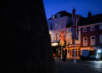 United Kingdom banners are illuminated by a headlight in the street outside Windsor Castle on Sept. 12, 2025, in Windsor, England.