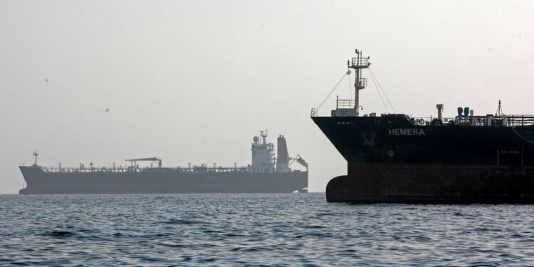 A ship remains anchored on May 16, 2026, in the Strait of Hormuz near Larak Island, Iran.