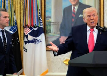 President Donald Trump takes questions as Secretary of War Pete Hegseth looks on during a ceremony for newly sworn in Secretary of the Department of Homeland Security Markwayne Mullin in the Oval Office at the White House on March 24, 2026, in Washington, D.C.