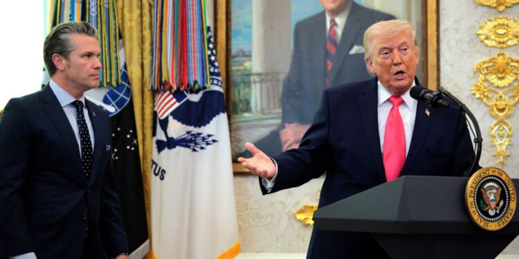 President Donald Trump takes questions as Secretary of War Pete Hegseth looks on during a ceremony for newly sworn in Secretary of the Department of Homeland Security Markwayne Mullin in the Oval Office at the White House on March 24, 2026, in Washington, D.C.