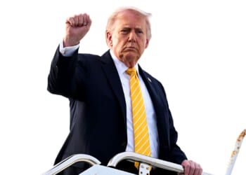 President Donald Trump raises his fist as he boards Air Force One.