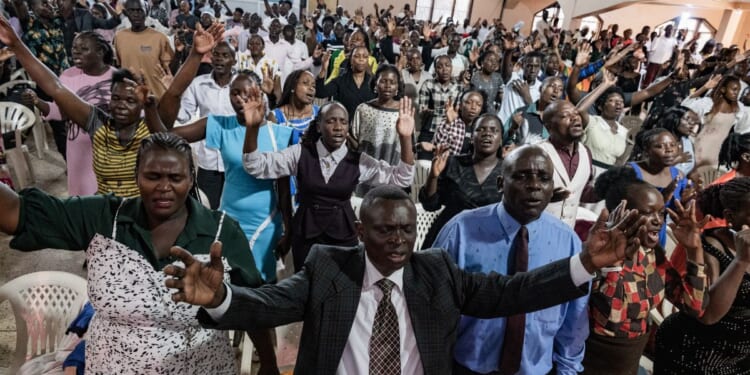 Christians raise their hands in worship at a church in Kampala, Uganda on Jan. 11, 2026.
