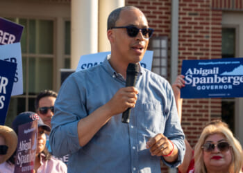 Jay Jones in blue shirt and sunglasses speaks at a 2025 campaign event.