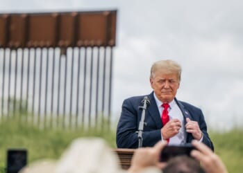 President Donald Trump pulls out his notes before speaking during a tour to an unfinished section of the border wall on June 30, 2021, in Pharr, Texas.