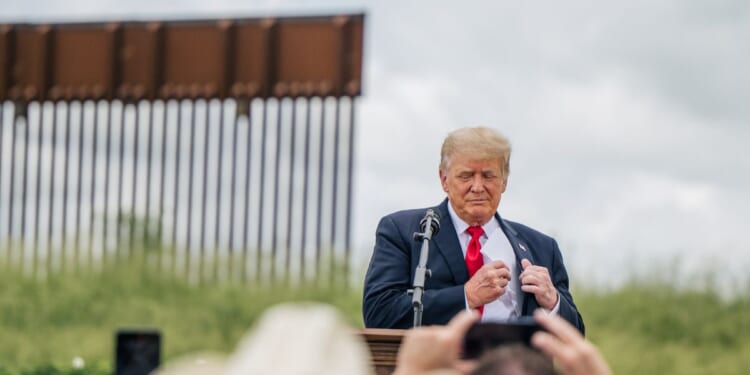 President Donald Trump pulls out his notes before speaking during a tour to an unfinished section of the border wall on June 30, 2021, in Pharr, Texas.