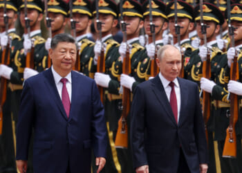 Xi Jinping and Vladimir Putin walk along a row of Chinese soldiers.