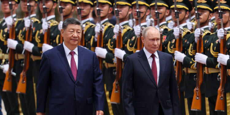 Xi Jinping and Vladimir Putin walk along a row of Chinese soldiers.