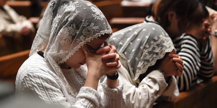 Two girls and one woman, all praying