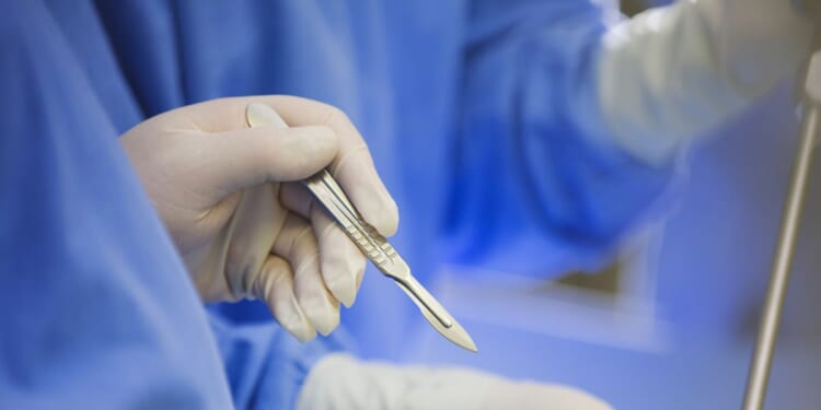 A surgeon using a scalpel during surgery.