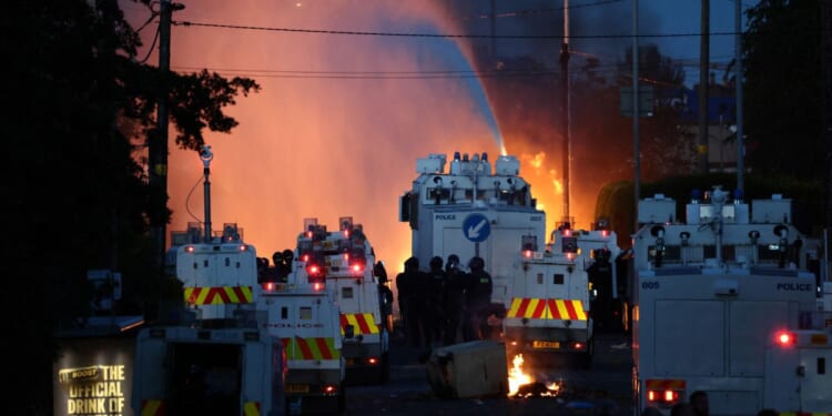 Police use a water cannon Wednesday as they block the road from protesters in Glengormley, north of Belfast, Northern Ireland.